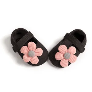 Detailed macro view of soft sole knitted infant princess shoes with large pink flowers
