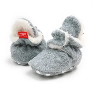Close-up of gray fleece winter baby booties with soft sole and faux fur lining
