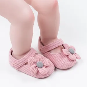 Detailed view of pink knitted baby princess shoes with 3D flower decoration