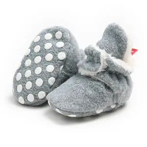 Detail view of gray plush baby winter booties with soft anti-slip dotted sole.