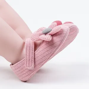 Close-up of pink knit baby walking shoe featuring a 3D decorative flower detail
