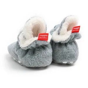 Detailed macro view showing the soft grey fuzzy texture and warm white fleece lining of baby booties