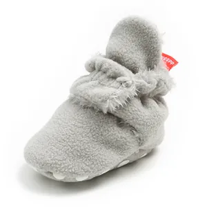 Macro detail of soft fleece grey winter baby bootie with anti-slip sole and strap
