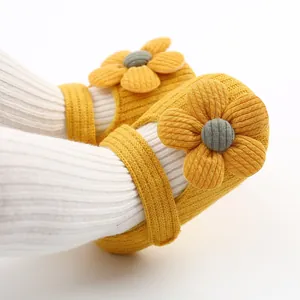 Macro detail of yellow knitted baby girl princess shoes with large flower decoration