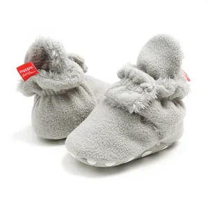 Detailed view of grey plush baby pre-walker booties with soft non-slip sole