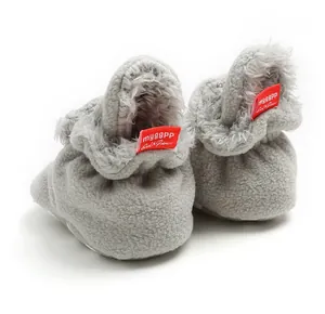 Detail of grey fleece baby booties with soft soles and warm winter lining for infants.