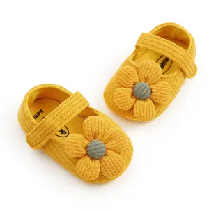 Detailed macro view of soft yellow knitted baby girl shoes with 3D flower decoration