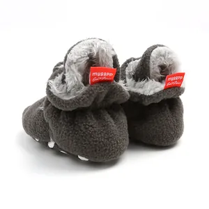 Rear view of warm winter baby booties featuring soft fleece lining and red brand labels.