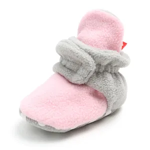 Detail shot of cozy pink and grey fleece baby booties with warm soft fuzzy lining