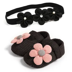Detailed view of baby girl knit floral shoes and matching headband set in dark brown