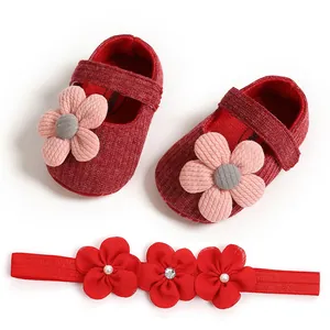 Macro view of red knit baby princess shoes and matching floral headband set for girls