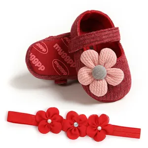 Detailed view of red infant girl princess shoes with large flower and matching floral headband