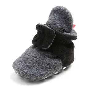 Close-up of grey and black fleece baby booties with soft non-slip soles for winter