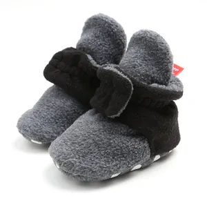 Close-up detail of warm grey fleece baby booties with soft soles for winter