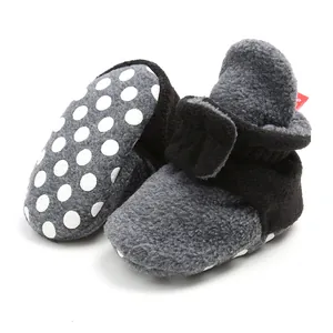 Detailed view of soft fleece winter baby booties with polka dot anti-slip soles