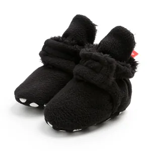 Close-up of black fleece baby booties with soft grip soles for winter