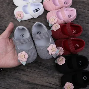 Close-up view of cute baby girl princess walking shoes with floral button decoration