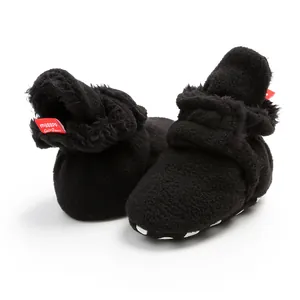 Detailed macro shot of warm black fleece baby winter booties featuring soft anti-slip soles