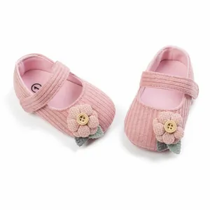 Close-up of pink infant princess shoes with cute knit flower and wooden button