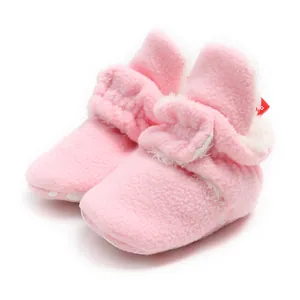 Detail of soft pink fuzzy winter baby booties with warm plush lining for infants