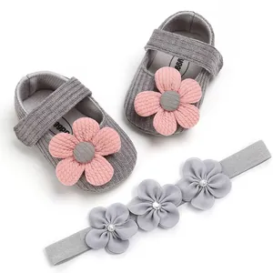 Adorable grey knit baby princess shoes with pink flowers and matching headband detail view