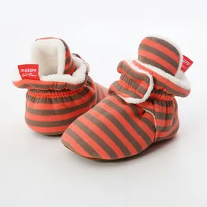 Detail view of orange and grey striped baby booties featuring a warm white fleece lining