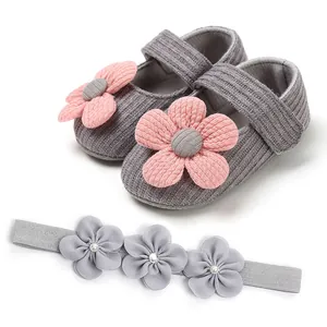 Detail of grey knit baby princess shoes with pink flowers and matching headband set