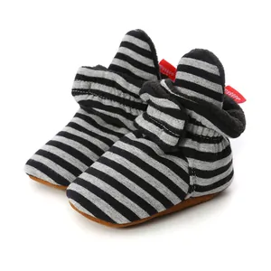 Close-up of striped baby walker shoes with soft soles and grey-black stripe patterns.