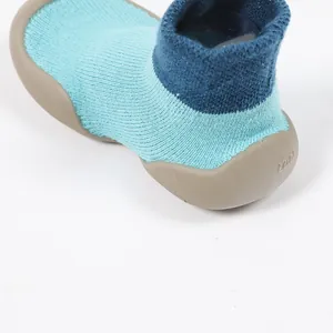 Nahaufnahme von Baby-Hausschuhen mit rutschfester Gummisohle und blauem Strickgewebe