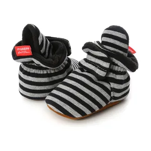 Close-up view of soft sole striped baby sock shoes with warm black fleece lining inside.
