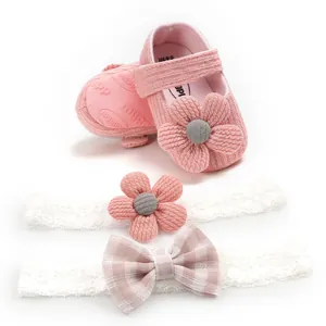 Close-up of pink knitted baby princess shoes with matching flower and bow headbands.