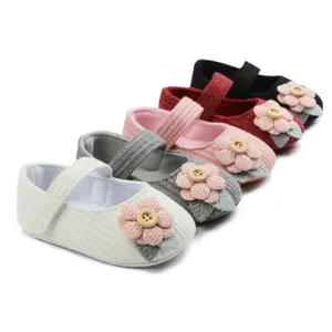 Assorted colors of knitted baby princess shoes with flower button details for infants.