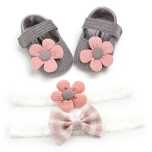 Macro detail of baby girl grey knitted shoes and white lace headbands with flowers