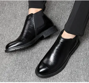 Detailed view of men's black leather Chelsea boots paired with formal dress pants