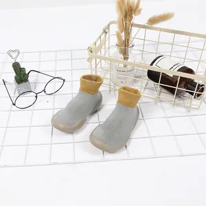 Detailaufnahme der rutschfesten Babysocken mit weicher Sohle aus grauem und gelbem Strick