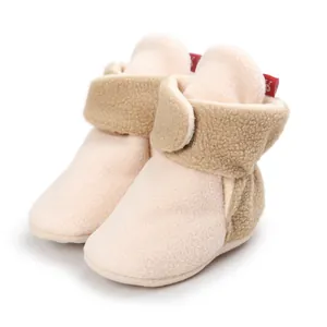 Detailed view of soft fleece baby booties with brown sherpa velcro strap for secure fit