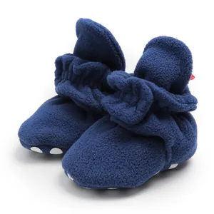 Close-up detail view of navy blue fleece baby booties with soft anti-slip soles.