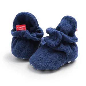 Close-up of navy blue fleece baby booties with soft soles for warm winter wear