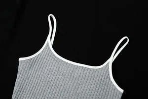 Détail en gros plan d'un caraco gris côtelé avec bordure et fines bretelles blanches