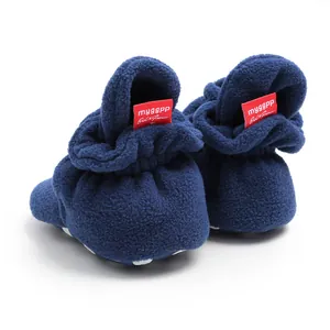 Close-up detail of navy blue fleece baby winter boots featuring red brand tag on heel