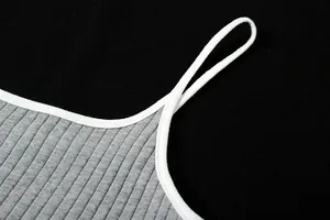 Détail macro de la bordure blanche contrastée sur une robe moulante en tricot gris