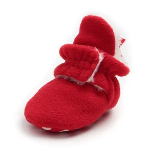 Close-up of red plush baby winter boot with soft white fur lining detail