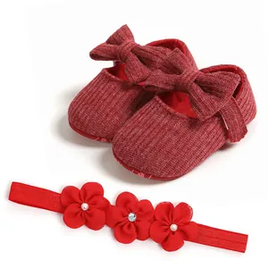 Zapatos de bebé de punto rojo con lazo y diadema floral a juego vista de detalle