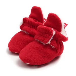 Close-up of red fleece baby winter booties with soft faux fur lining and adjustable strap.