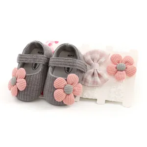 Detail view of gray knitted baby girl princess shoes and floral headband gift set