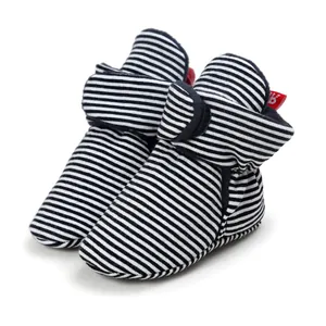 Close-up of soft-sole baby booties with classic black and white stripes for infants.