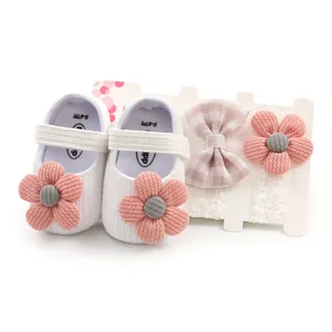 Detail view of baby girl shoe set with pink flower embellishments and matching headbands