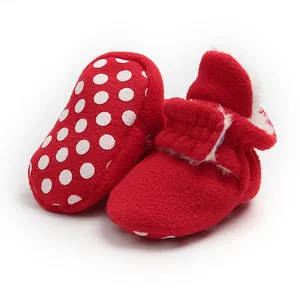 Detail view of red polka dot baby booties with warm fleece lining and a flexible soft sole.