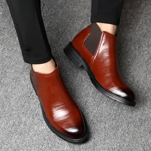 Classic brown leather men's Chelsea boots featuring a sleek business formal design on a model