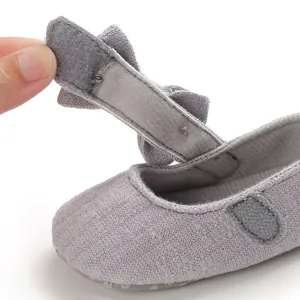 Detailed view of the adjustable hook-and-loop strap on a soft-sole grey baby walker shoe